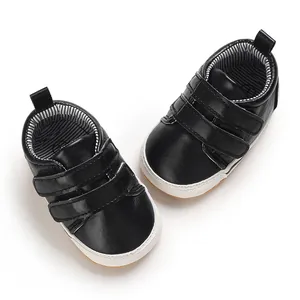 Detail view of black baby walker shoes with hook-and-loop straps and non-slip white rubber soles