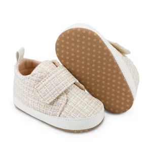 Detaillierte Makroansicht beige gewebter Baby-Lauflernschuhe mit weicher Gummisohle