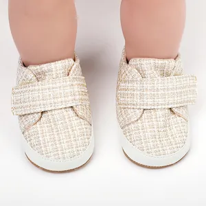Detailaufnahme von weichen Baby-Lernlaufschuhen aus cremefarbenem Tweed.