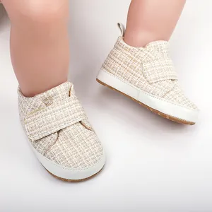 Nahaufnahme von gewebten Babyschuhen mit weichen weißen Sohlen und Klettverschluss