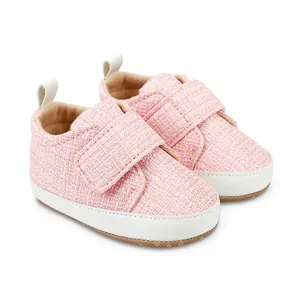 Detailansicht rosa Baby-Stoffschuhe mit weißer weicher Sohle und Klettverschluss.