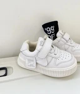 Close-up of white toddler walking shoes with soft soles and convenient velcro straps