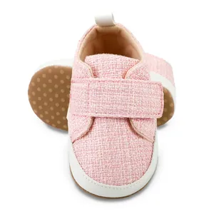 Detailansicht eines rosa gewebten Baby-Lauflernschuhs mit verstellbarem Klettverschluss