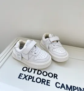 Side view of white toddler sneakers with Velcro straps and thick soft soles