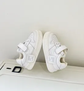 Detailed view of white toddler sneakers with Velcro straps and soft non-slip soles