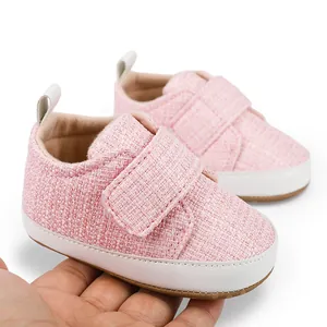 Nahaufnahme von rosa gewebten Babylauflernschuhen mit Klettverschluss und weicher Sohle.