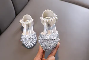 Nahaufnahme silberner Mädchen Prinzessinnenschuhe mit Kristall- und Perlendekor