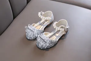Nahaufnahme glitzernder silberner Prinzessinnenschuhe für Mädchen mit Perlen und Kristallen.