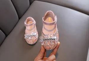 Detailopname van roze glitter prinsessenschoenen voor meisjes met strass-bloem