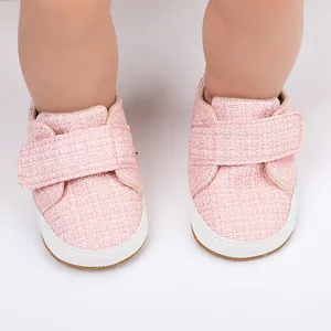 Nahaufnahme von rosa gewebten Baby-Lauflernschuhen mit weicher weißer Gummisohle