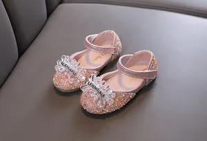 Detailopname van roze prinsessenschoenen voor meisjes met strassteentjes en kristallen strik