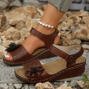 Bequeme braune Keilsandaletten mit Blumenmuster und dicker Sohle für Damen am Strand
