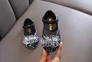 Detailweergave van de fonkelende strass bloem op zwarte prinsessenschoenen voor meisjes