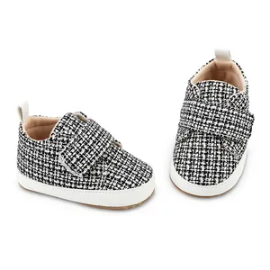 Details von Baby-Lauflernschuhen mit schwarz-weißem Tweed-Muster und Klettverschluss-Riemen