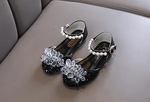 Detailansicht schwarzer Mädchen-Prinzessin-Schuhe mit Kristallblume und Perlenriemen