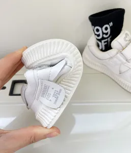 Macro detail of highly flexible white leather toddler walking shoes with soft sole.