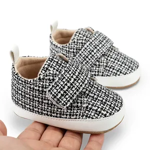 Detailansicht von schwarz-weißen Tweed-Babyschuhen mit praktischem Klettverschluss