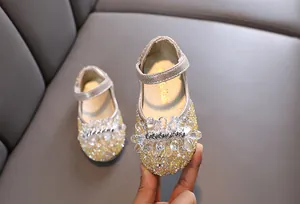 Gedetailleerd overzicht van champagne prinsessenschoenen voor meisjes met kristallen bloemen.