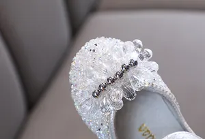 Detail van fonkelende zilveren strass-steentjes en kristallen kralen op prinsessenschoenen.