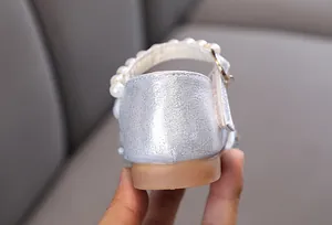 Detailansicht der silbernen glitzernden Mädchen-Prinzessin-Schuhe mit Perlenriemen