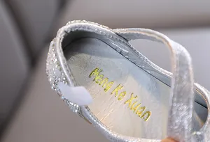 Gedetailleerd macro-zicht op zilveren prinsessenschoenen voor meisjes met stras en parels