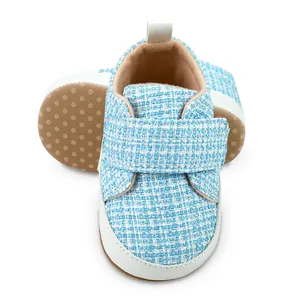 Detailansicht aus blauem Karostoff und weicher rutschfester Sohle für Baby-Lernlaufschuhe