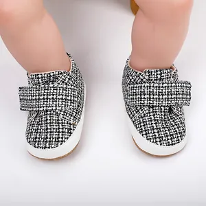 Detailansicht der Baby-Lauflernschuhe mit schwarz-weißem Tweed-Muster und Klettverschluss