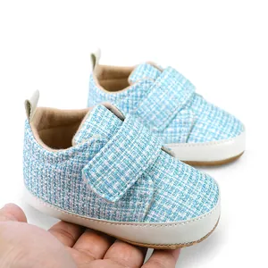 Nahaufnahme von weichen Baby-Lernlaufschuhen mit blauem Karostoff und Klettverschluss