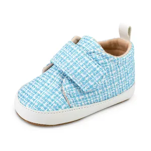 Nahaufnahme von weichen Baby-Lernlauflernschuhen mit blauem Karomuster und Klett