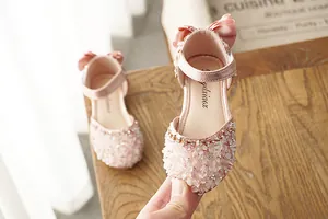Close-up of pink girls' rhinestone sandals with sparkling crystals and bow detail