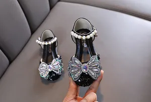 Gros plan détaillé de chaussures de princesse noires pour filles avec nœud en strass et perles