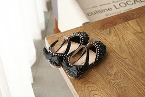 Detailed view of black rhinestone girls' sandals with an elegant back bow.