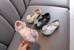 Vista detallada de los zapatos de princesa para niñas con pedrería y un lazo brillante