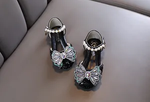Vue macro détaillée de chaussures de princesse noires pour filles avec nœud en strass et perles