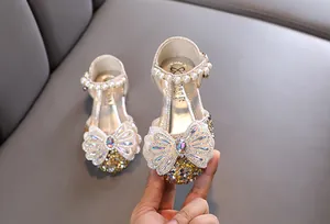 Détail des sandales de princesse dorées pour filles avec nœud en strass et perles