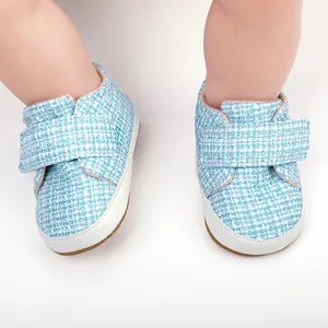 Detail von weichen Baby-Lernlaufschuhen mit blauem Tweed-Stoff und Klettverschluss