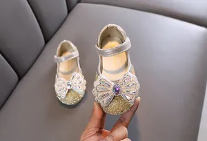 Primer plano de zapatos de princesa para niña con un gran lazo de strass muy brillante