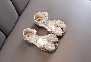 Vue détaillée du nœud papillon scintillant sur sandales de princesse argentées
