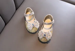 Elegantes zapatos de princesa dorados para niña con un gran lazo de pedrería