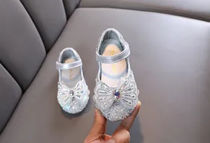 Primer plano del detalle de lazo con diamantes de imitación en zapatos de princesa para niñas