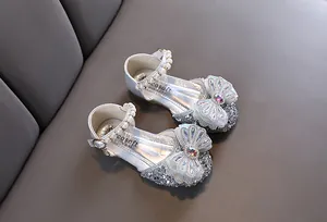 Chaussures de princesse argentées étincelantes avec nœud en strass et bride en perles.