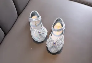 Vista macro detallada de zapatos de princesa con lentejuelas plateadas y lazo de diamantes