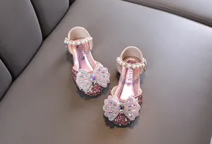 Vue détaillée de chaussures de princesse roses pour filles avec un nœud en strass.