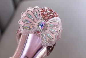 Détail du nœud en strass étincelant avec une gemme sur sandales de princesse roses