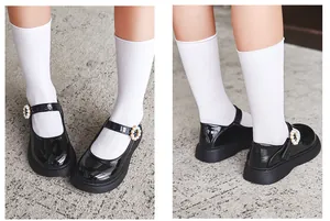 Close-up detail of black patent leather girls Mary Jane shoes featuring pearl buckles