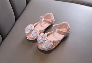 Primer plano de zapatos de princesa rosas para niña con diamantes de imitación y lazo