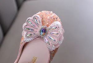 Primer plano macro de zapatos de princesa rosas con un lazo de diamantes de imitación