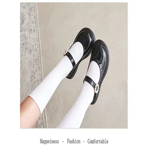 Close-up of girls' black patent leather Mary Jane shoes with pearl buckles and white socks