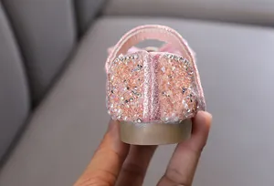 Primer plano detallado del talón en zapatos de princesa con purpurina rosa para niñas