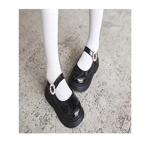 Close-up of black patent leather Mary Jane shoes for girls with pearl flower buckles
